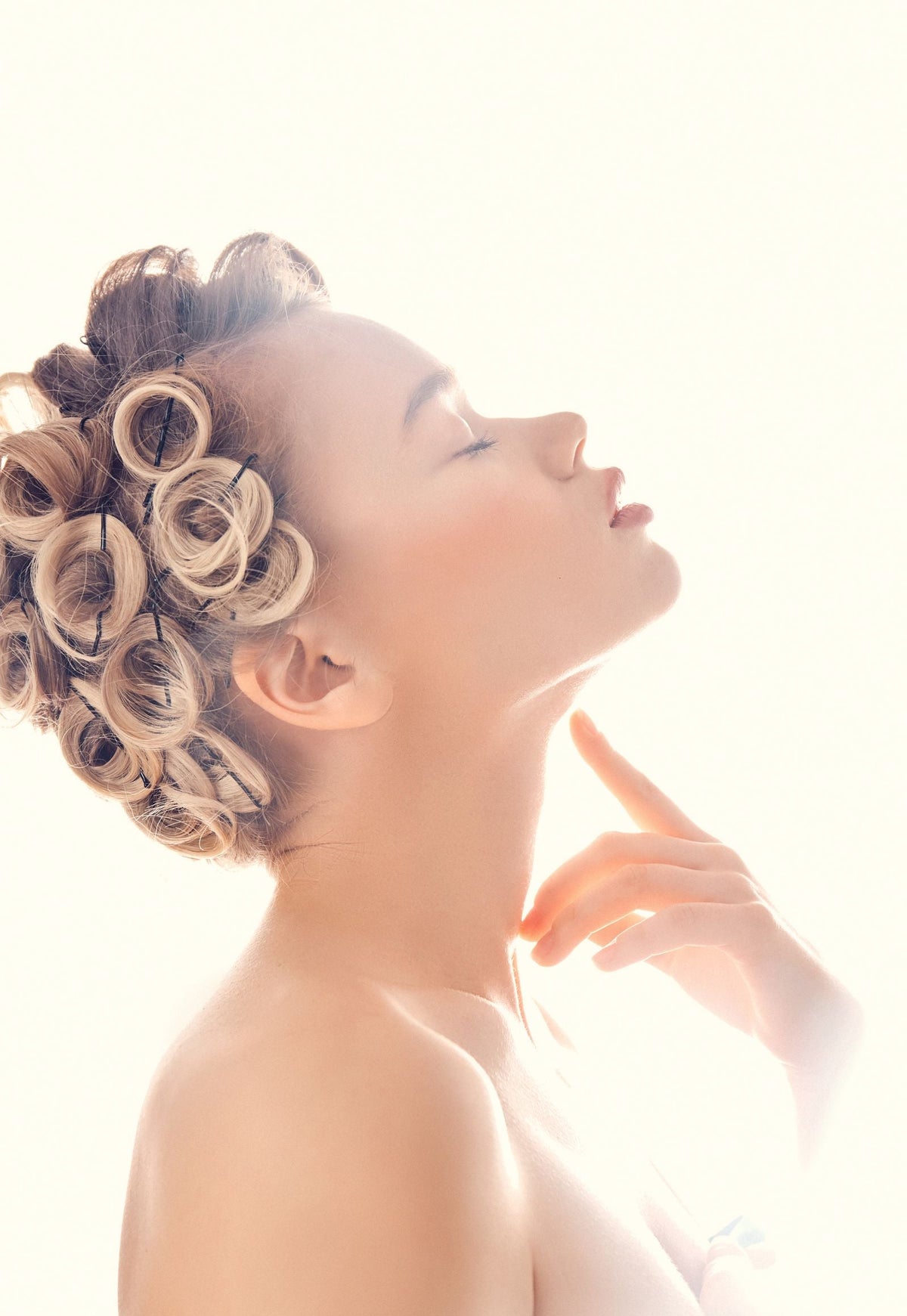 Jeune femme de profil avec des boucles réalisées sans chaleur, lumière douce