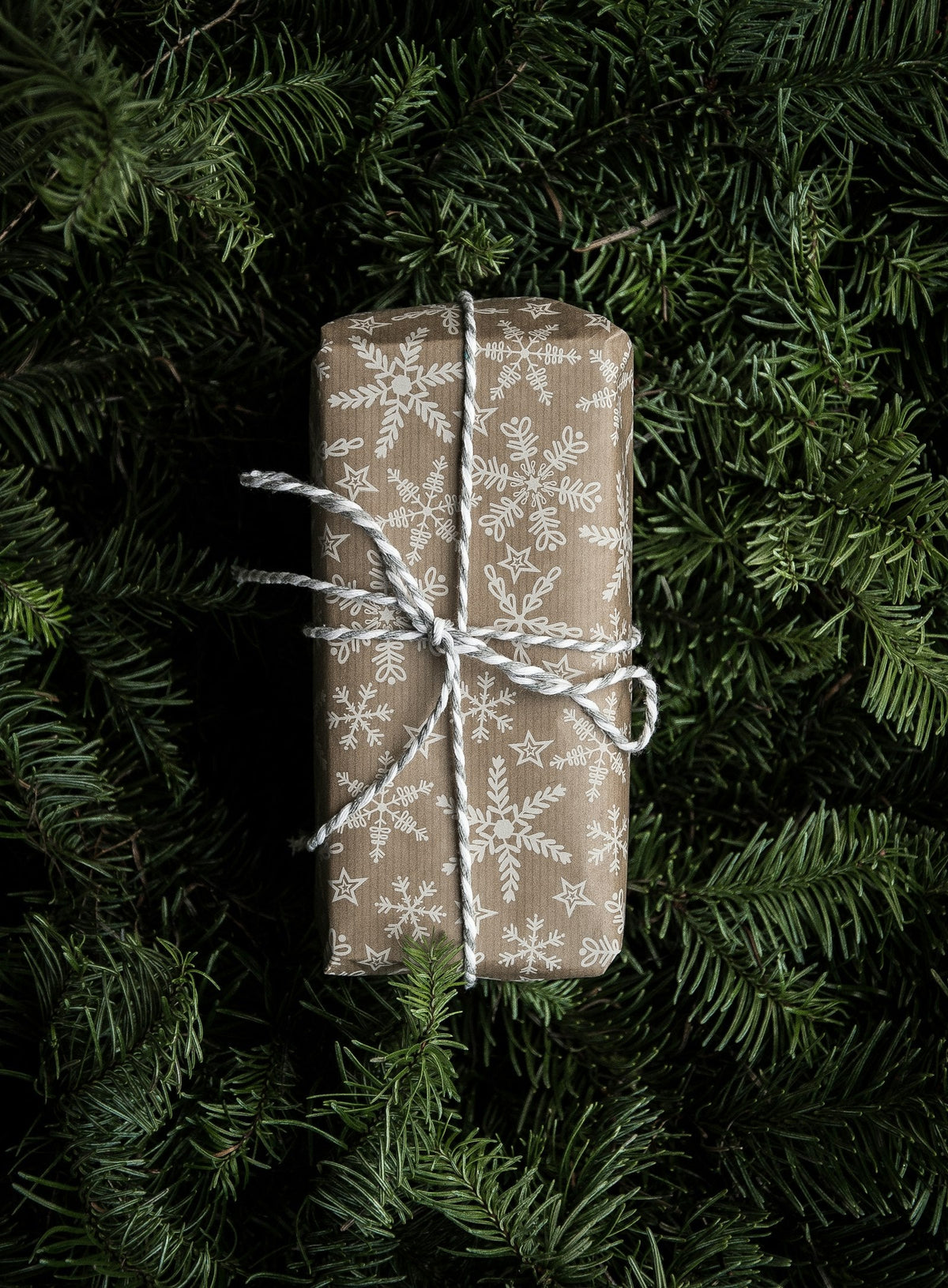 Paquet cadeau emballé dans un papier kraft et blanc, idée cadeau beauté pour Noël