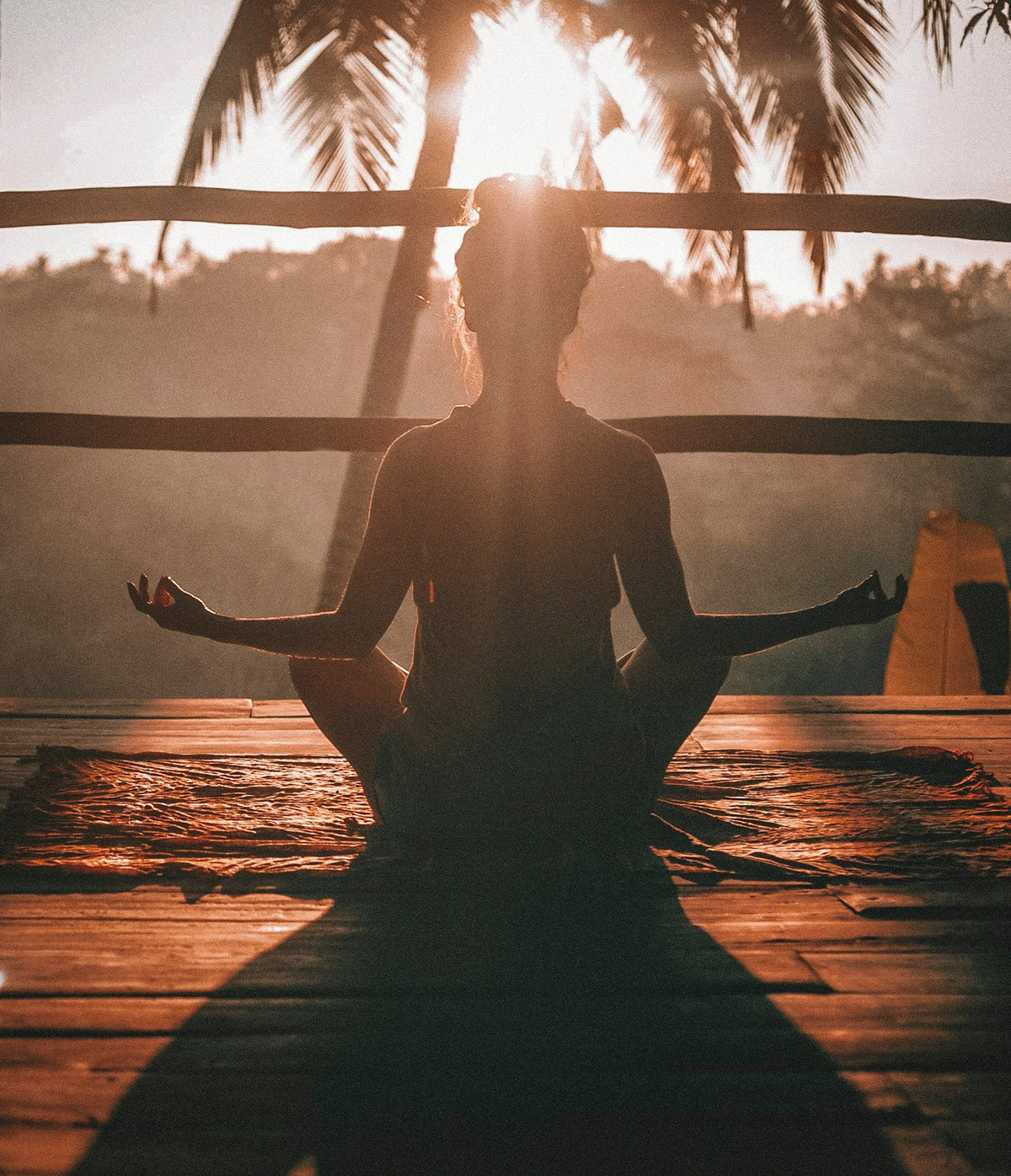 Femme en séance de yoga matinale dans une lumière dorée