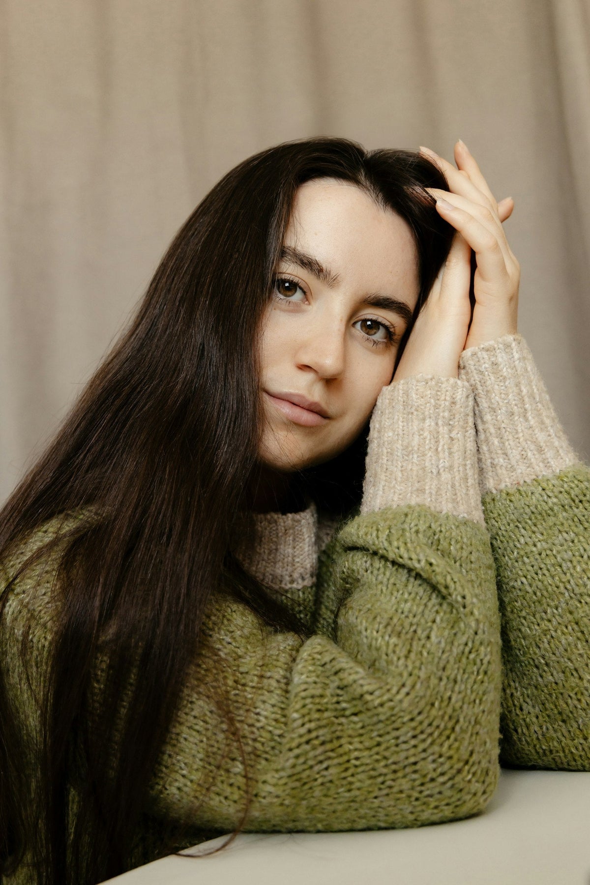 Femme aux cheveux longs bruns en pull douillet : protéger ses cheveux secs en hiver