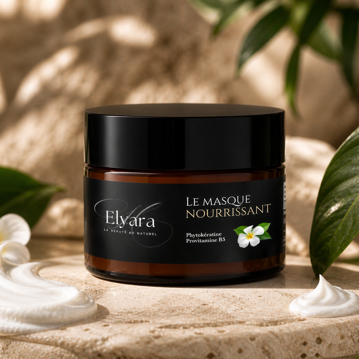 Pot à masque capillaire noir et amber Elyara, étiquette “Le Masque Nourrissant” avec fleurs blanches, posé en décor naturel.